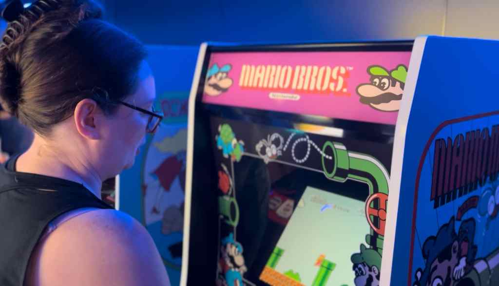 Image of Kelly playing Mario Bros. arcade.