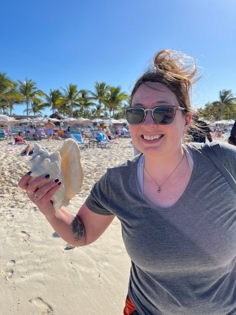Kelly holding a conch on the beach in Bimini